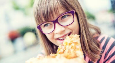 Girl eating pizza with braces